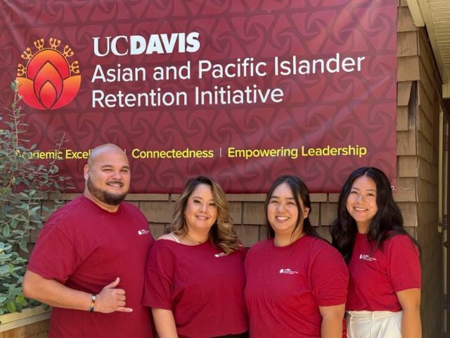 Pro-staff member wearing red shirts in front of the office banner 