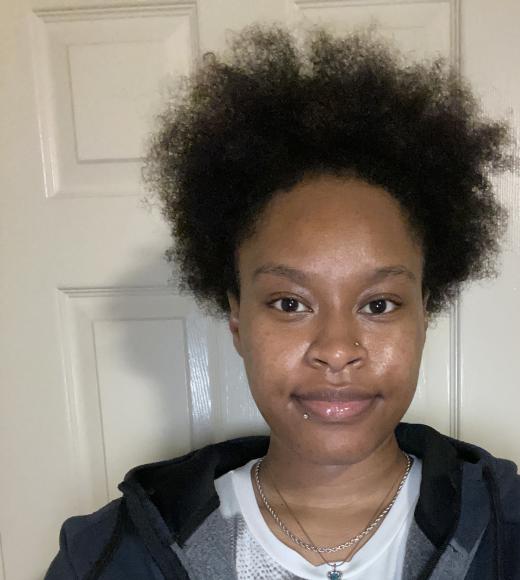 Profile picture of Faapuloua standing behind a white door