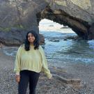 Adhithi profile picture in front of a giant gray rock and blue ocean in the background