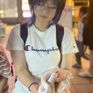 Photo of Carly wearing a white shirt with a black backpack holding a white snake