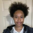 Profile picture of Faapuloua standing behind a white door